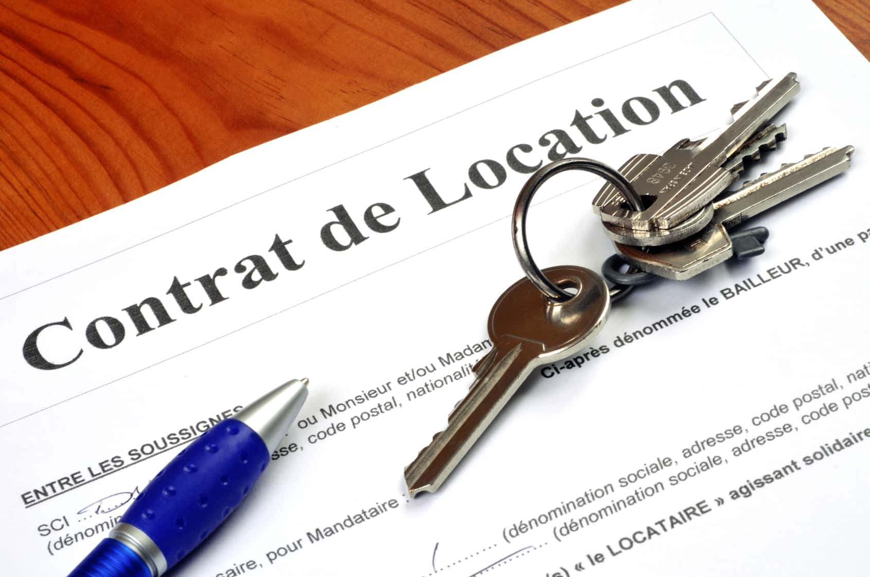 contrat de location : main signant un contrat avec un stylo