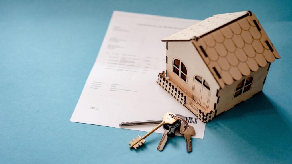 assurance emprunteur : contrat d'assurance et maison en arrière-plan